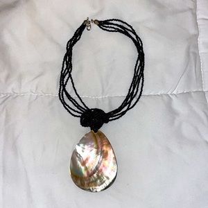 Large abalone shell on black beaded necklace is adjustable to choker if desired.